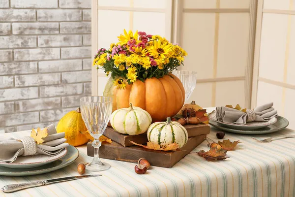 Güzel bir buket sonbahar çiçeği servis masasında balkabağında.
