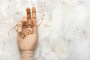 Ahşap manken eli, Grunge arka planında şık mücevherler, yakın plan.