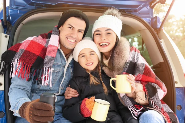 冬の日に車のトランクで熱いお茶を飲む幸せな家族 — ストック写真
