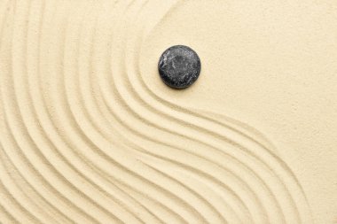 Açık kumdaki siyah spa taşı