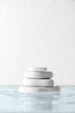 Beyaz arkaplanda suya konmuş spa taşları yığını
