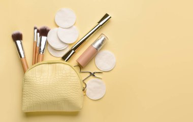 Farklı fırçalar, kozmetik ürünleri, cımbız ve renk arkaplanı üzerine temiz pamuk pedleri.