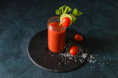 Koyu arkaplanda bir bardak Bloody Mary olan tahta.