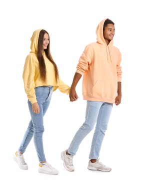 Stylish young couple in hoodies holding hands on white background clipart