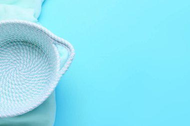 Mavi arkaplanda boş sepet ve kumaş, yakın plan.