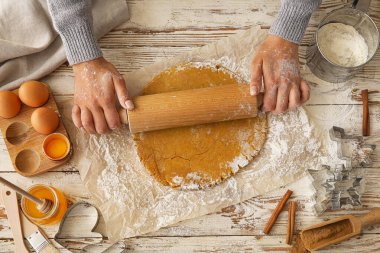 Kadın masaya zencefilli ekmek yuvarlıyor.