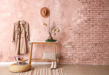 Noel toplarıyla dolu ağaç dalları pembe koridordaki masanın üstünde.