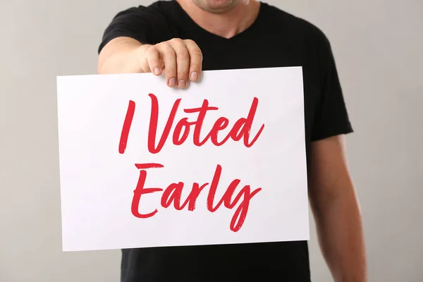 Man Holding Poster Text Voted Early Grey Background — Stock Photo, Image