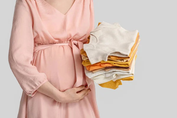 Young Pregnant Woman Stack Baby Clothes Light Background — Stock Photo, Image