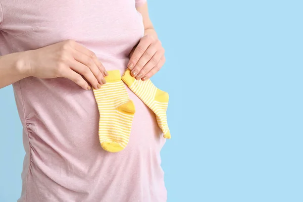 Mujer Embarazada Joven Con Calcetines Bebé Sobre Fondo Azul Primer — Foto de Stock