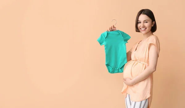 Jonge Zwangere Vrouw Met Baby Bodysuit Beige Achtergrond — Stockfoto