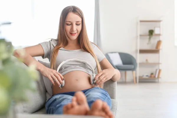 Mujer Embarazada Joven Con Auriculares Sentados Sofá Casa —  Fotos de Stock
