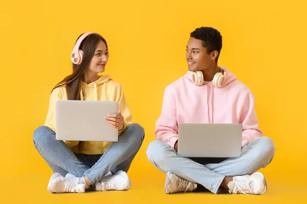 Stilvolles Junges Paar Kapuzenpullis Mit Laptops Auf Gelbem Hintergrund — Stockfoto