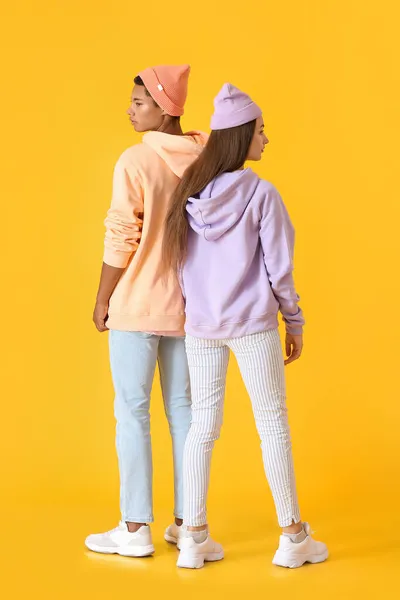 Elegante Pareja Joven Sudaderas Con Capucha Sobre Fondo Amarillo — Foto de Stock