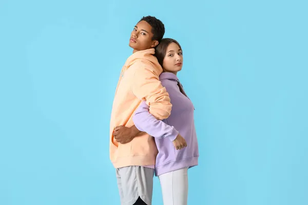 Deportiva Joven Pareja Sudaderas Con Capucha Sobre Fondo Azul — Foto de Stock