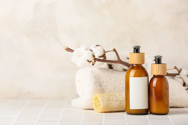 Flaschen Mit Kosmetikprodukten Handtuch Schwamm Und Baumwollzweig Auf Fliesentisch Vor — Stockfoto