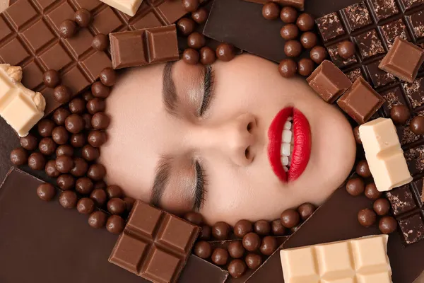 Лицо Красивой Молодой Женщины Окружении Различных Шоколадных Конфет — стоковое фото