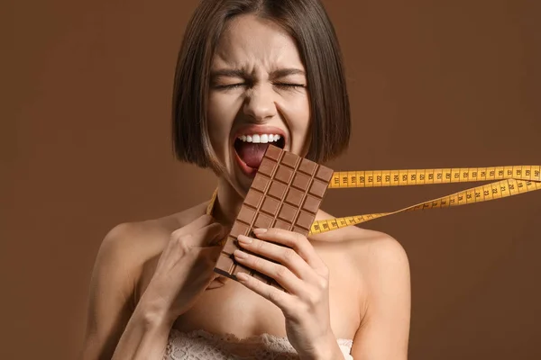Stressed Young Woman Sweet Chocolate Measuring Tape Color Background Diet — Stock Photo, Image