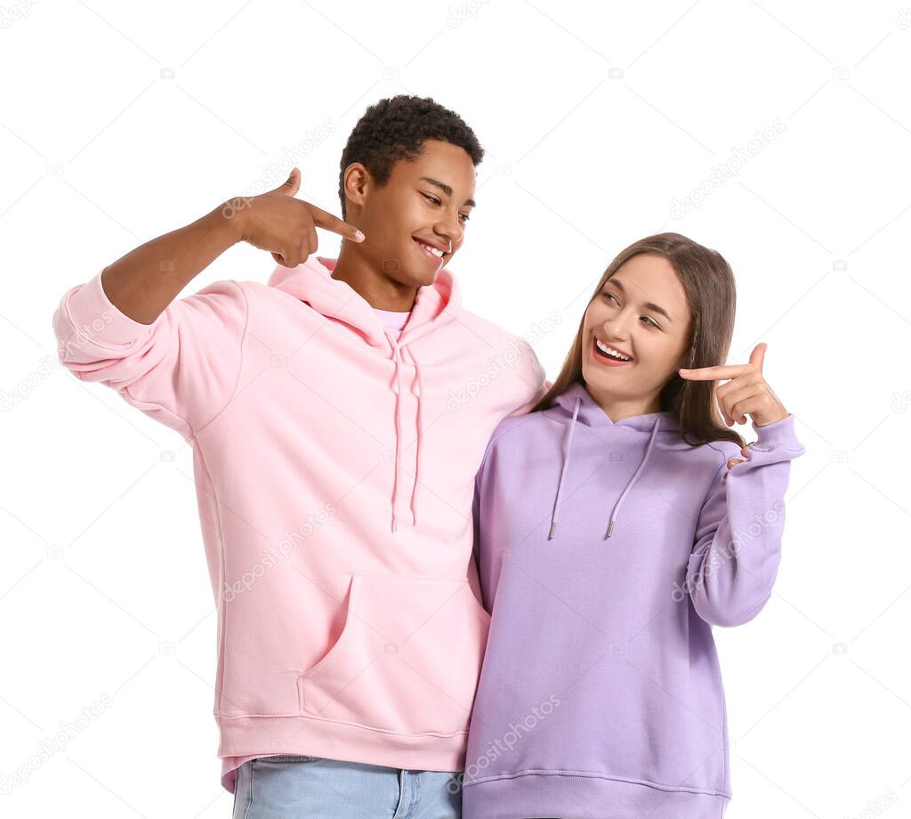 Stylish young couple in hoodies on white background