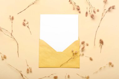 Renkli arkaplanda kurutulmuş çiçekler ve boş kartla zarf