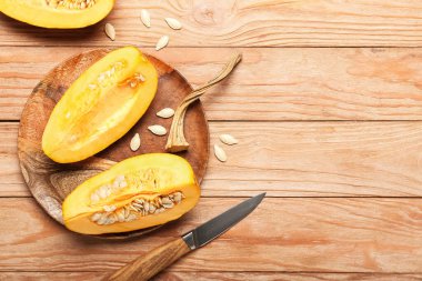 Kesilmiş balkabağı ve tahta zemin üzerinde bıçak tabağı.