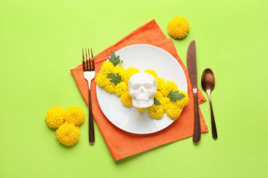 Meksika Ölüler Günü 'nde (El Dia de Muertos) insan kafatası ve yeşil arka planda çiçekler.