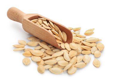 Beyaz arka planda doğal kabak tohumlarıyla kepçe