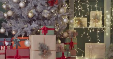 Oturma odasının içinde Noel ağacının altında hediyeler var.