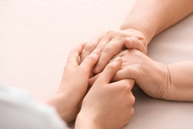 Masada büyükannenin elini tutan genç bir kadın.