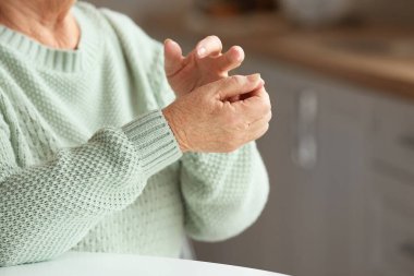 Evdeki yaşlı kadının elleri.