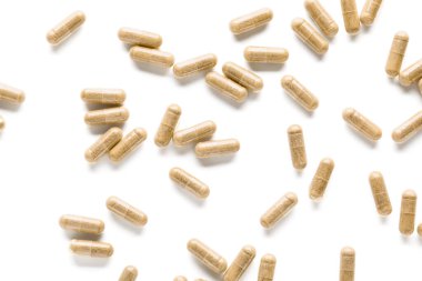 Vitamin K pills scattered on white background clipart