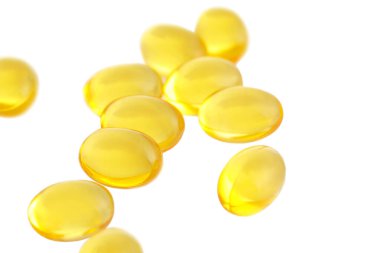 A vitamini hapları beyaz arka planda izole edilmiş, yakın plan