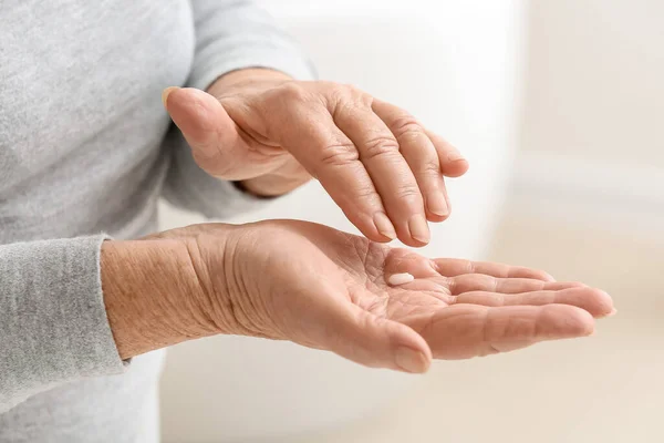 Donna Anziana Che Applica Crema Cosmetica Sulle Mani Bagno — Foto Stock