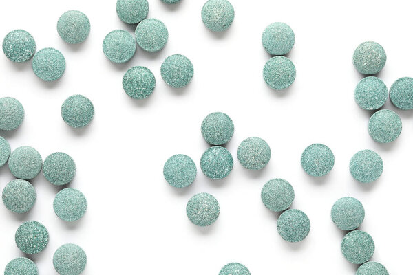 Vitamin K pills scattered on white background, closeup