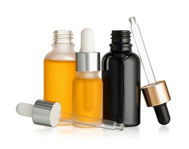 Beyaz arka planda farklı şişelerde gerekli yağ var.