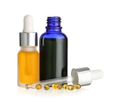 Beyaz zemin üzerinde izole edilmiş gerekli yağ ve kapsüller.