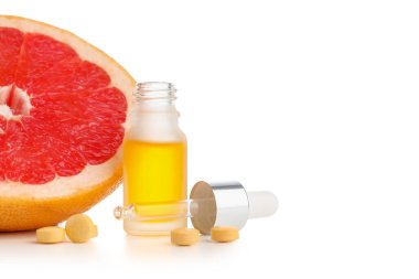 Beyaz arka planda gerekli yağ, hap ve greyfurt şişesi, yakın plan