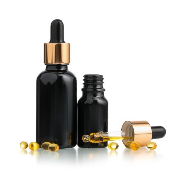 Beyaz zemin üzerinde izole edilmiş gerekli yağ ve kapsüller.