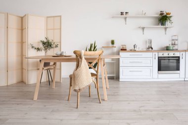 Ahşap yemek masası olan şık bir mutfak.