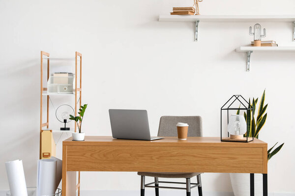 Stylish workplace near wall in room