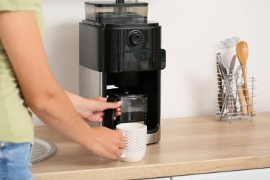 Güzel bir kadının mutfakta kahve makinesi kullandığı bir sabah.