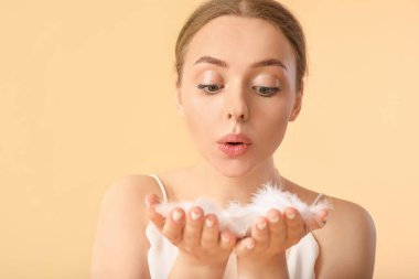 Renk arka planında yumuşak tüyleri olan güzel genç bir kadın.