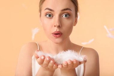 Renk arka planında yumuşak tüyleri olan güzel genç bir kadın.