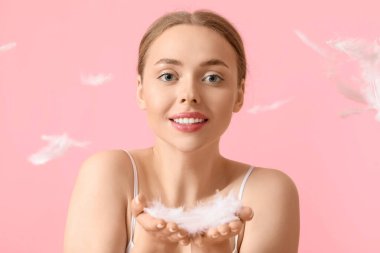 Renk arka planında yumuşak tüyleri olan güzel genç bir kadın.