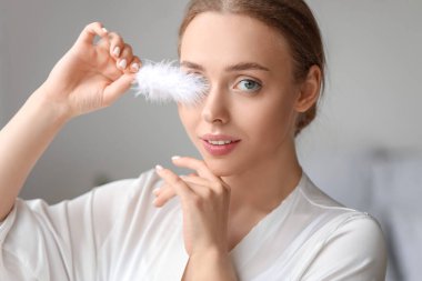 Evinde yumuşak tüyleri olan güzel genç bir kadın