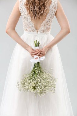 Açık arkaplanda çiçek demeti olan güzel gelin.