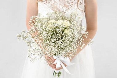 Açık arkaplanda çiçek demeti olan güzel gelin.