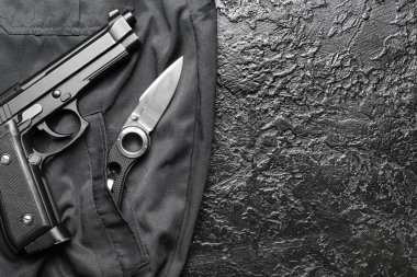 Siyah arka planda tabancası olan katlanmış bir çakı.