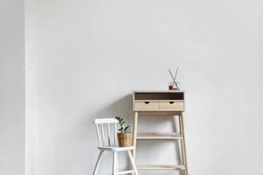 Ayakta duran masası ve sandalyesi olan aydınlık bir odanın içinde.