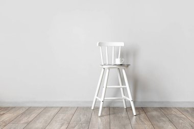 Işık duvarının yanında kahve ve şarjörlü sandalye.